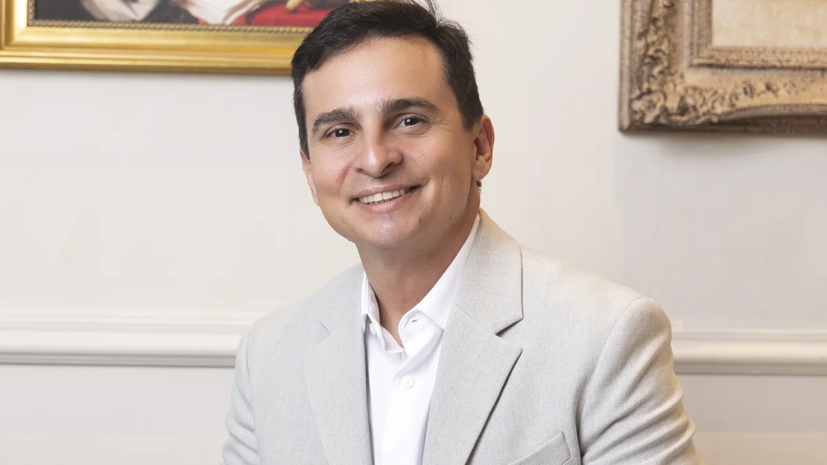 Alectomia: Dr. Eduardo Furlani, cirurgião plástico, sorrindo no consultório da clínica em Fortaleza