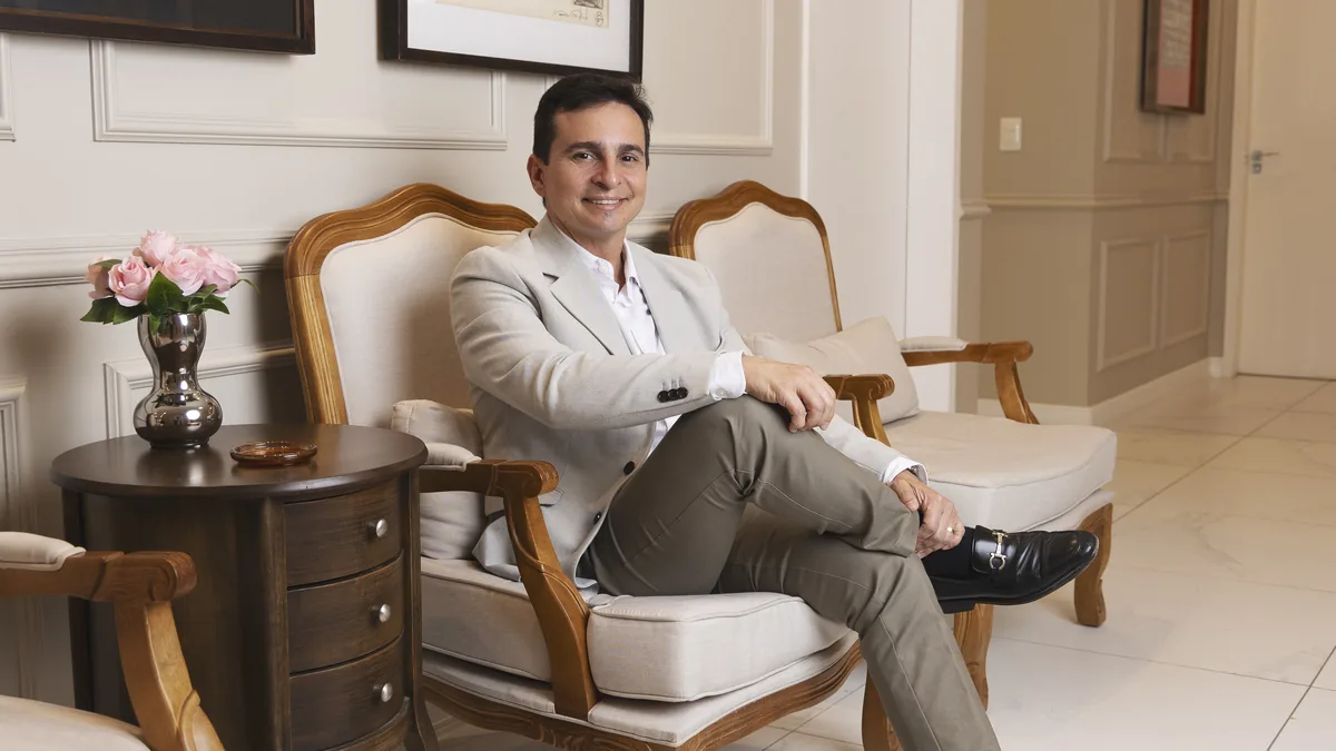 Como decidir fazer cirurgia plástica: Dr. Eduardo Furlani sentado na recepção da clínica em Fortaleza