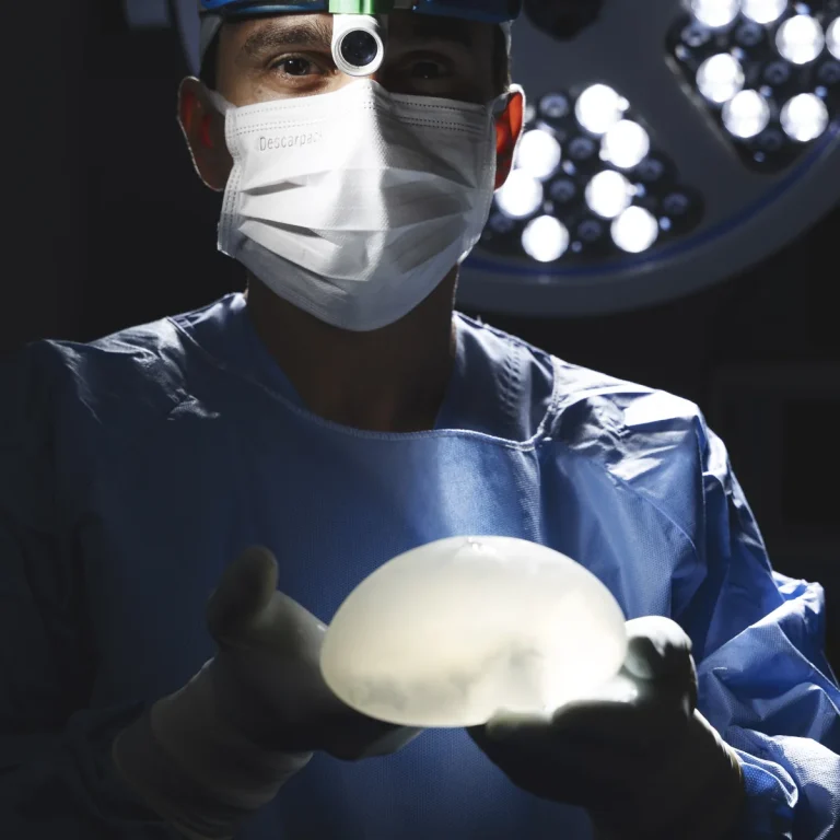 Dr. Eduardo Furlani no centro cirúrgico, com a prótese de silicone usada em alguns casos de mastopexia
